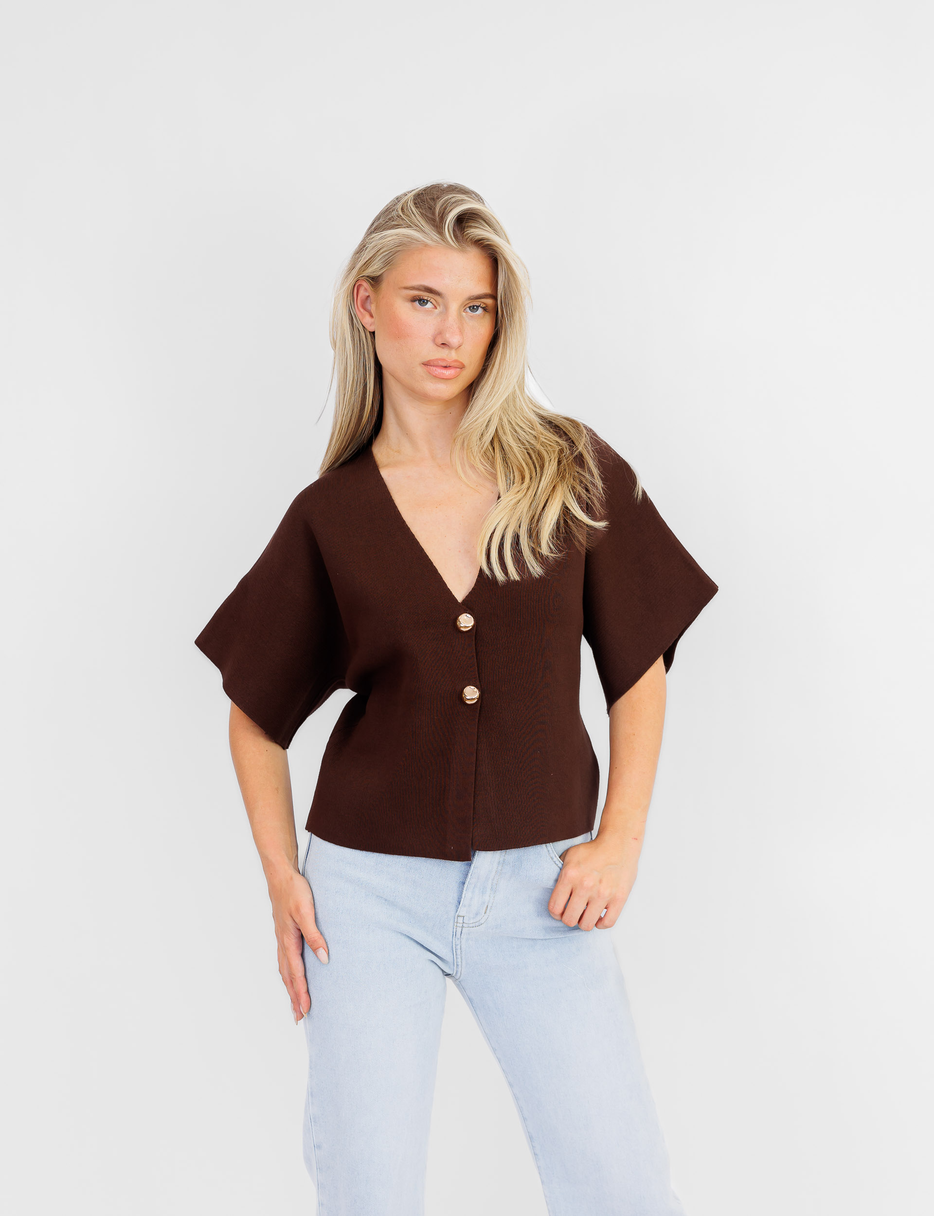 Jessica top in bruin met gouden knopen en korte uitlopende mouwen.
