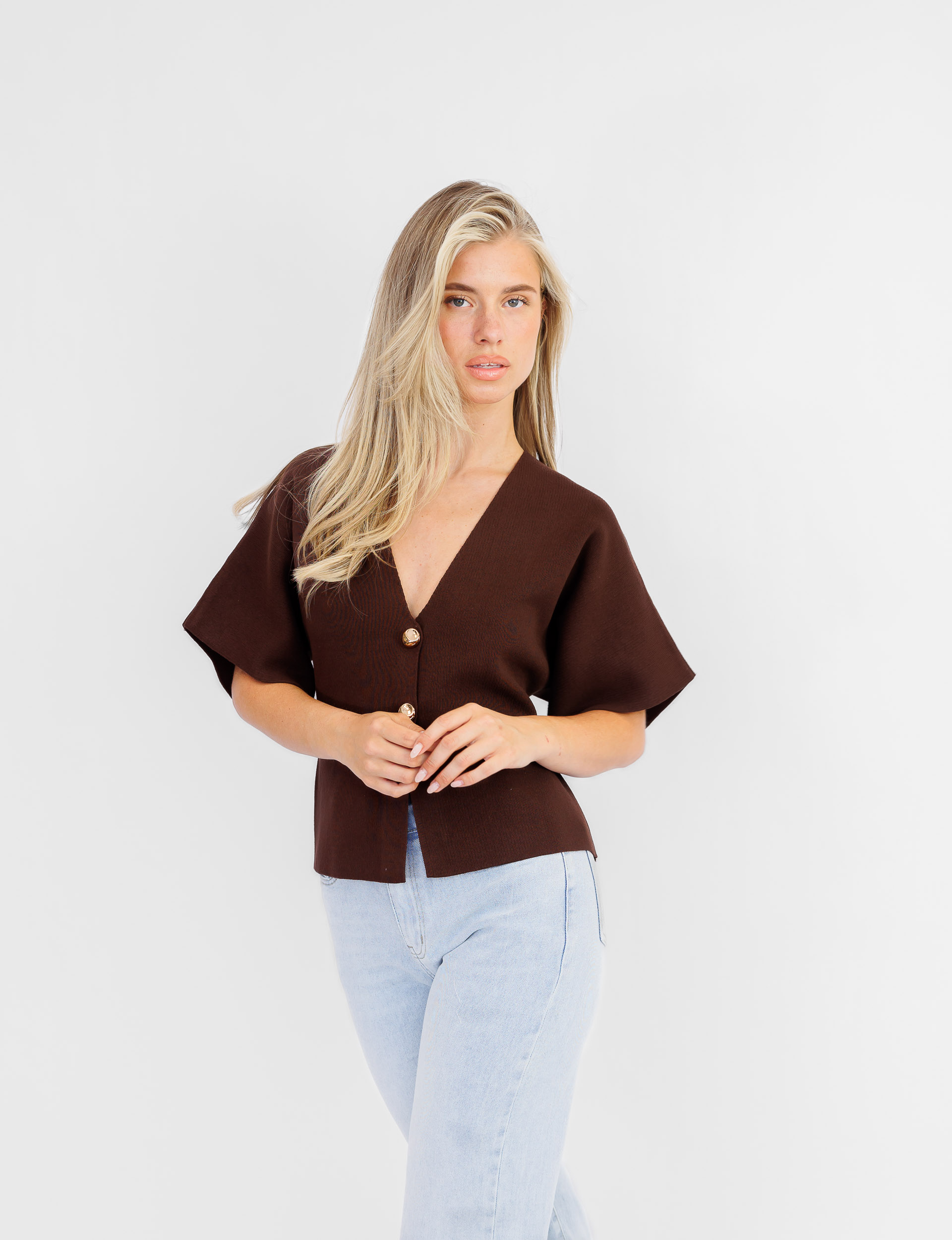 Jessica top in bruin met gouden knopen en korte uitlopende mouwen.